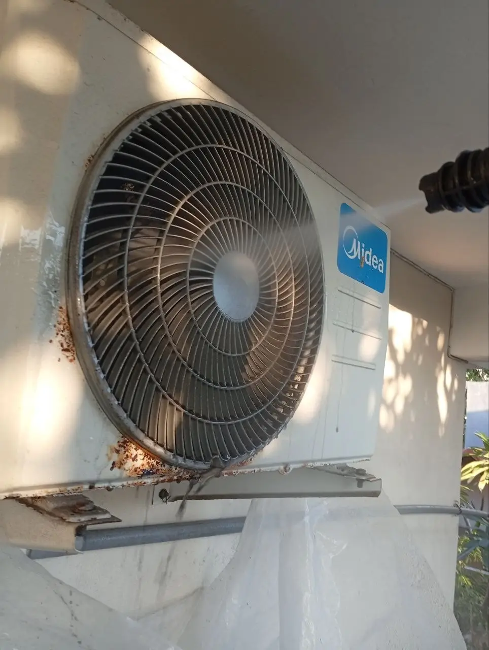 Wall-mounted outdoor AC condenser unit on a building in Bali